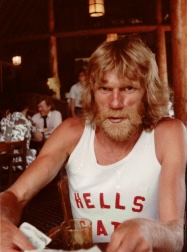 Al Howie sitting at a pub, drinking a beer, wearing a Hells Gate tank