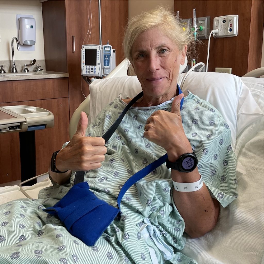 Reynolds in a hospital bed after passing out in a workout--smiling with two thumbs up.